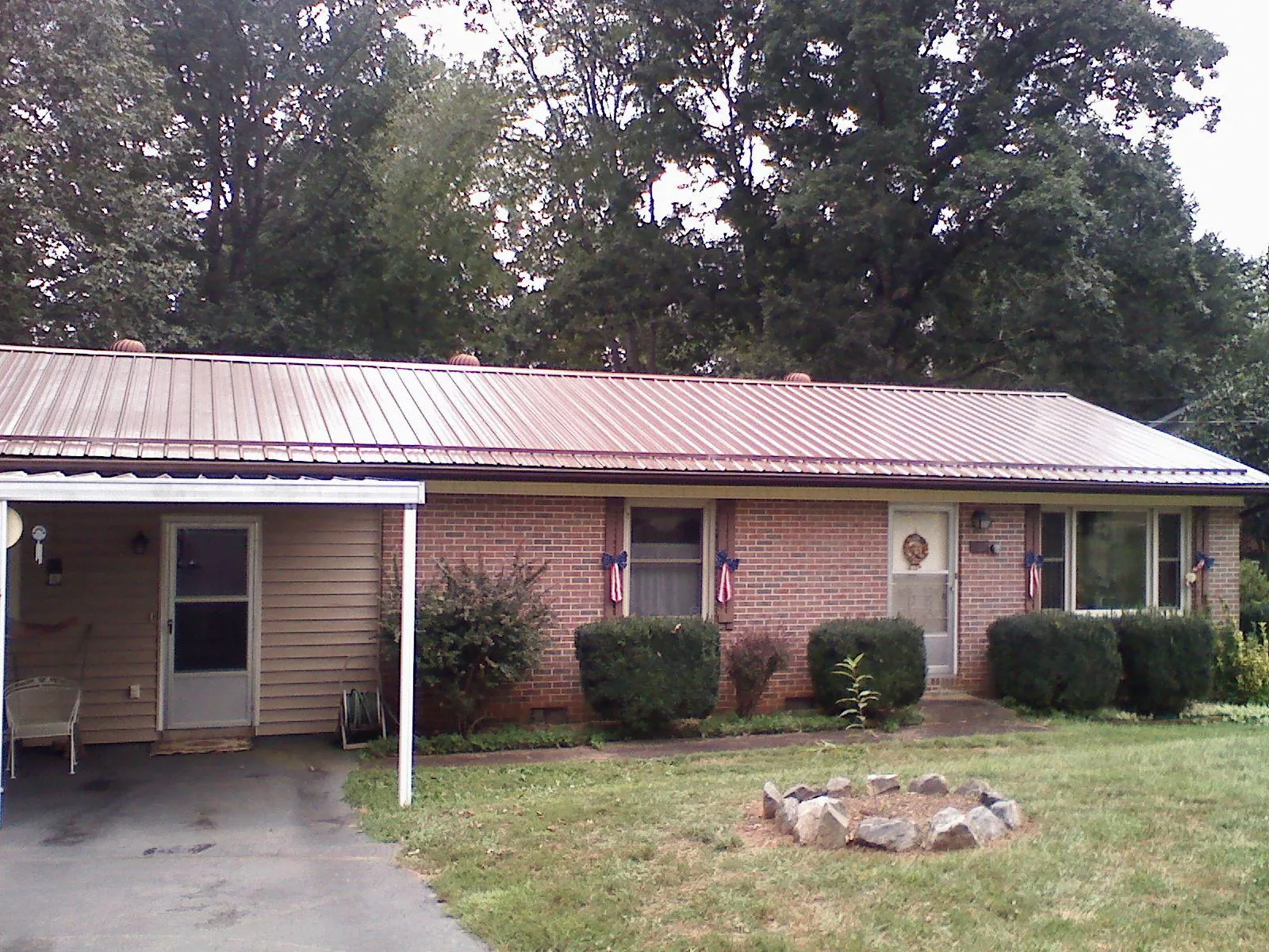 Bronze metal roof and carport on a brick ranch home — Roof Repair work by our crew in Stateline
